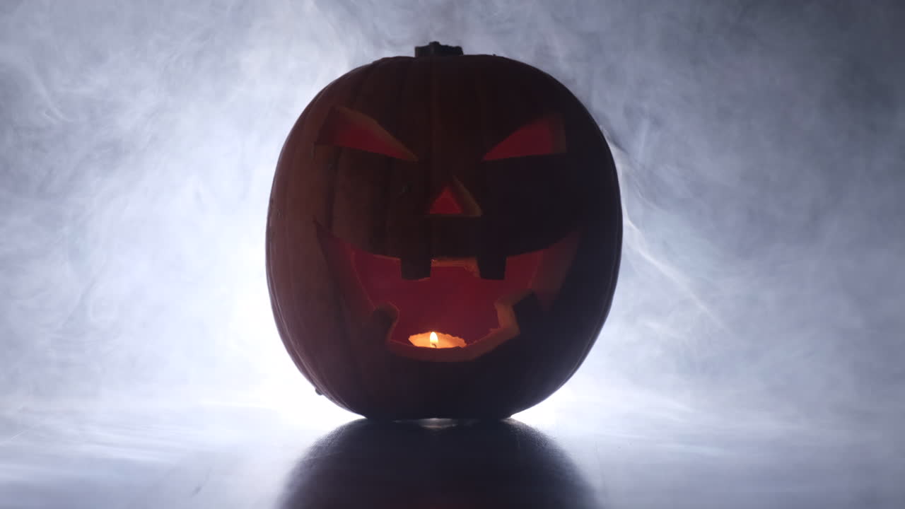 cara de calabaza brillante de halloween en niebla de humo oscuro