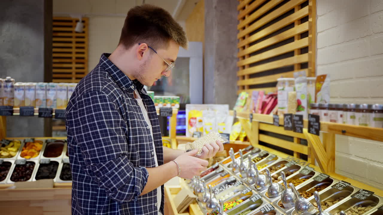 젊은 남자가 식료품 가게에서 간식을 구입하고 있다