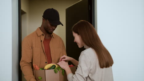 mujer recibiendo una caja de verduras