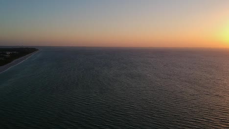 Volando-Sobre-Las-Olas-En-La-Isla-De-Sanibel-Mirando-Hacia-La-Playa-Hasta-El-Punto-Del-Faro