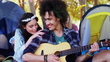 man playing guitar for his woman in park 4k