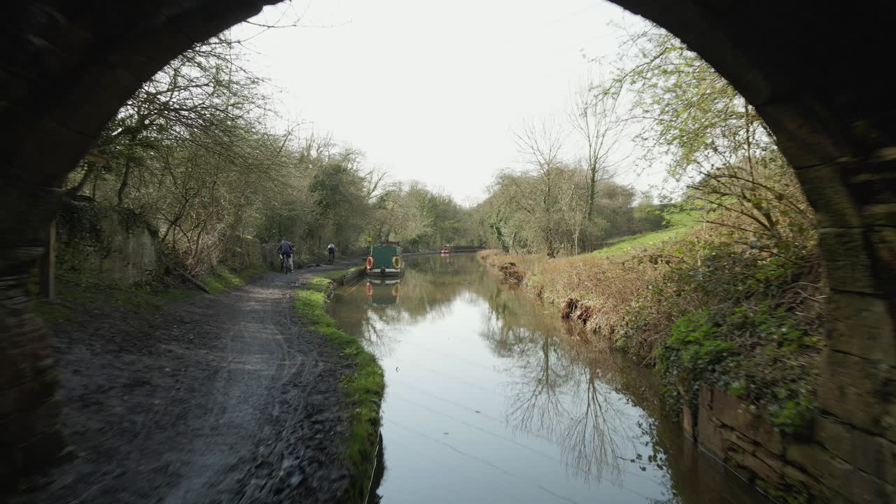 Softly Gliding Along Canal And Emerging Through Tunnel