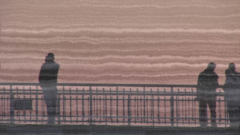 people in silhouette by railing