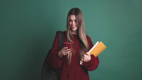 young woman student standing with books and smartphone
