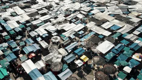 Aerial-View-Of-Tents-And-Stalls-At-Plaza-de-Ponchos-In-Otavalo,-Ecuador---drone-shot