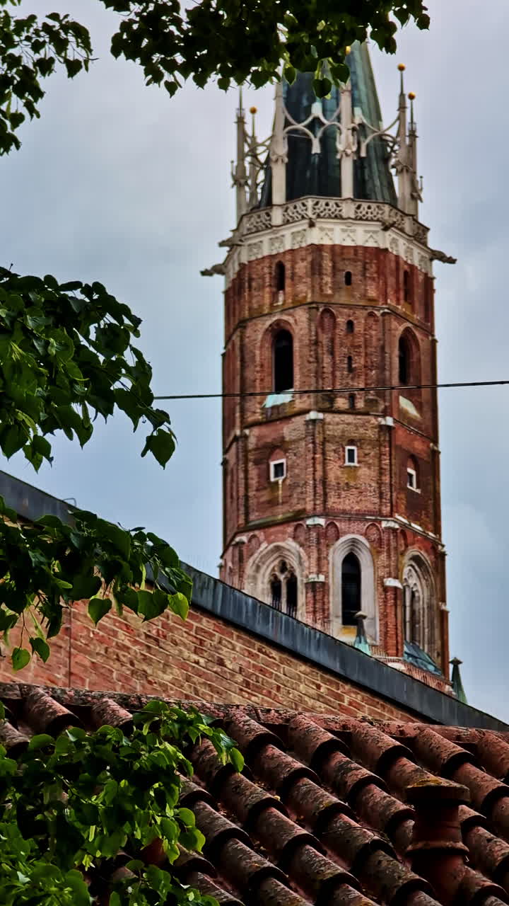 St. Martin’s Church Tower Framed by Trees in Landshut, Germany in vertical shot