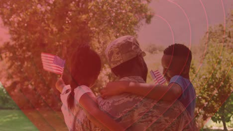 animation of hearts over back of african american soldier father holding kids with usa flags