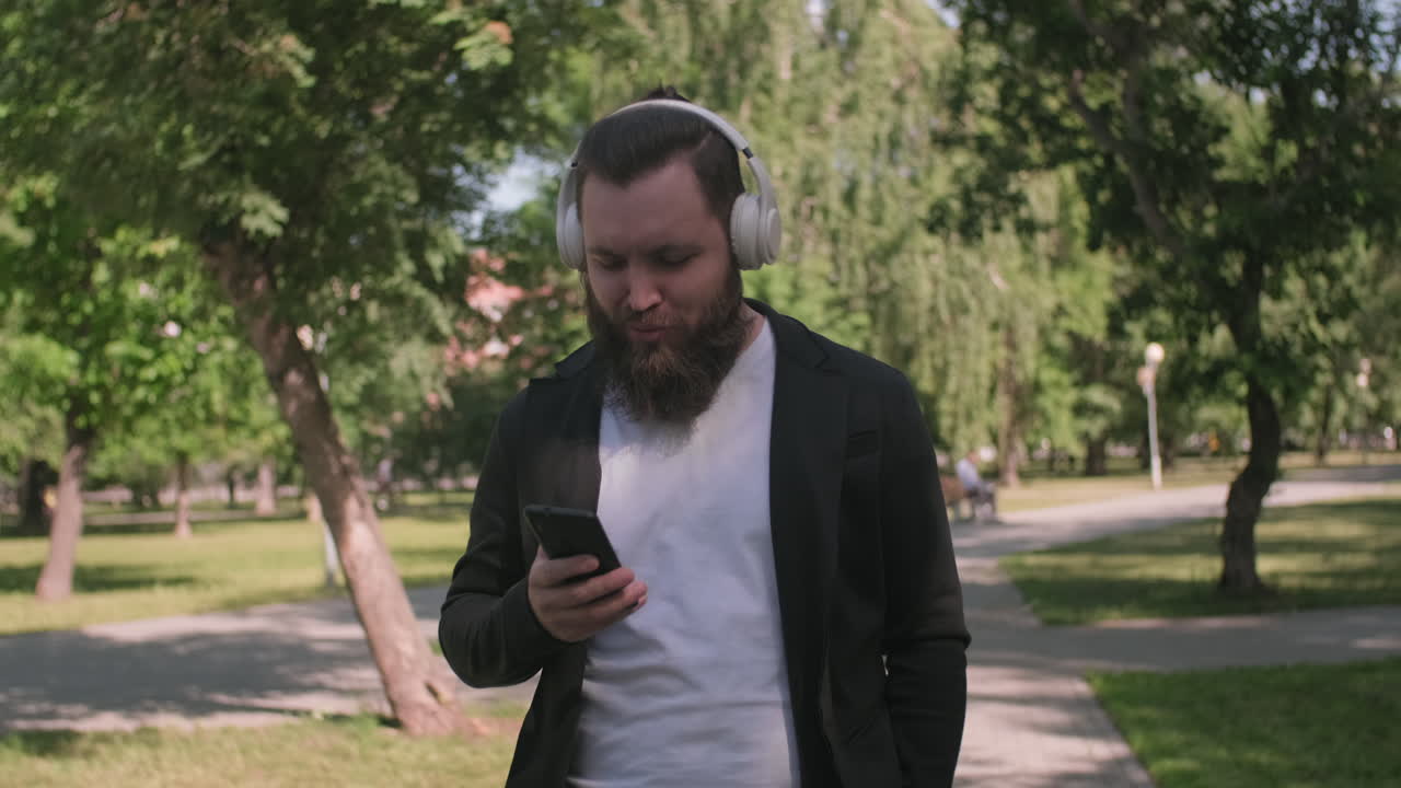 Man Listening to Music and Walking in Park