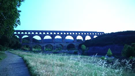 roman historical aqueduct with many celia stone arches over a river in france