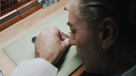 man inspecting and repairing wrist watch - close up