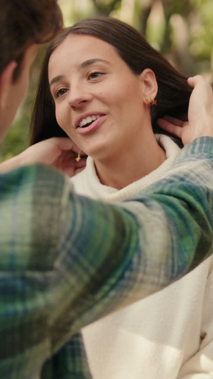 Close-up, happy young partners man and woman talking sitting in park