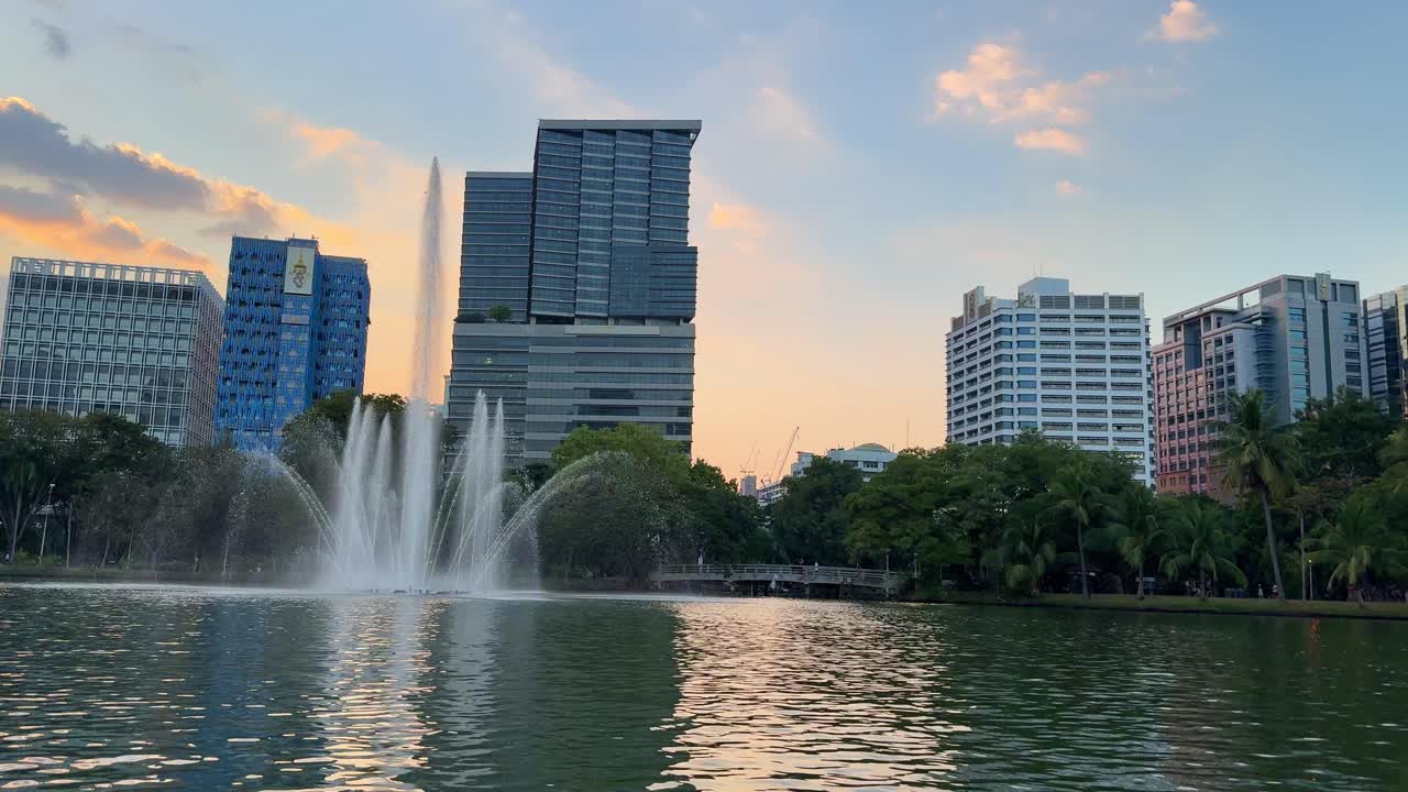 Parque urbano del Sudeste Asiático con lago y arquitectura moderna en Bangkok, Tailandia.