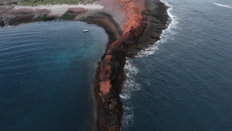 Boat-floating-on-sea-near-rocks