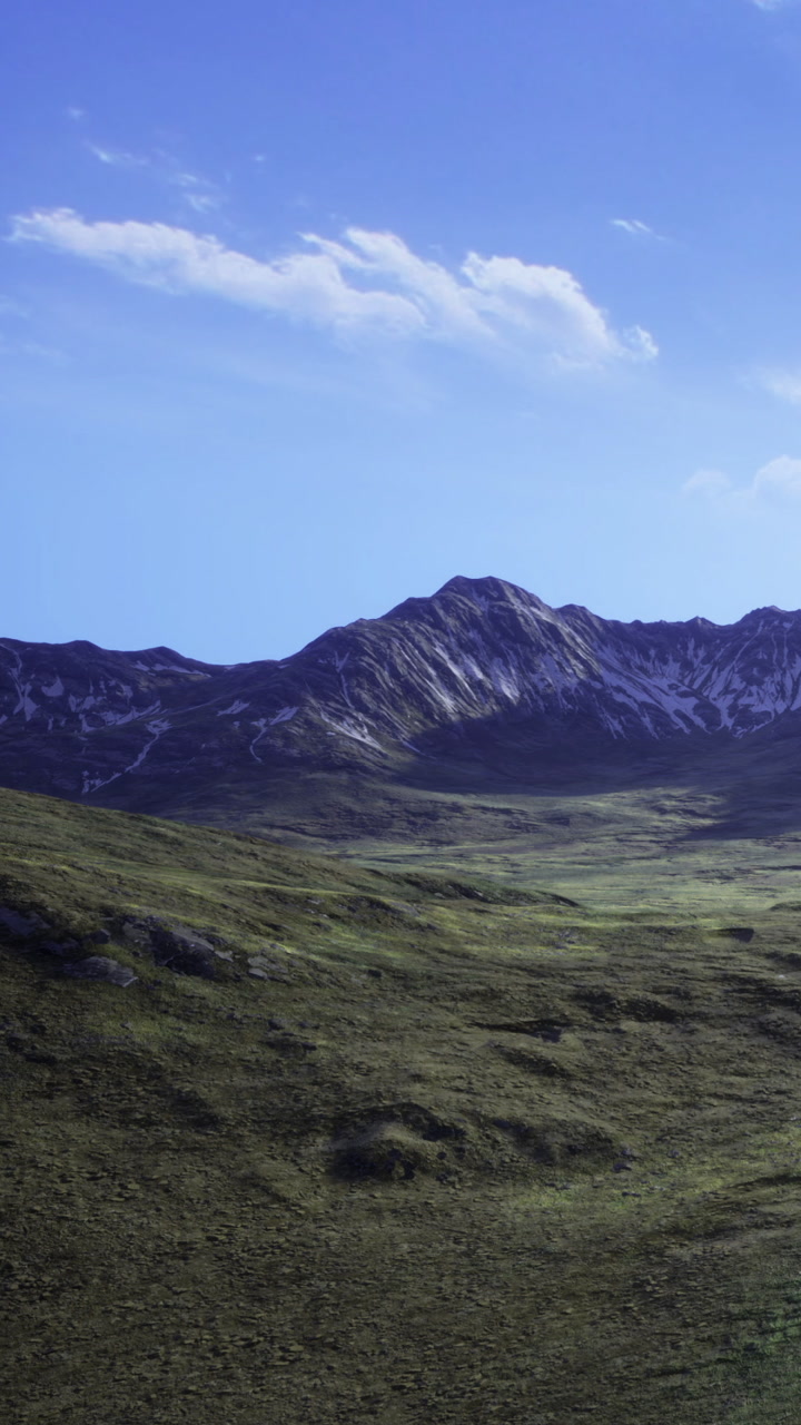 Mountains and grassland under blue sky on sunny day near landscape