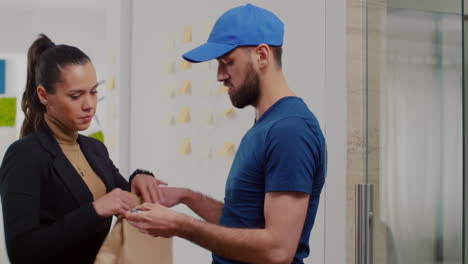 mujer de negocios que paga el pedido de comida para llevar con un reloj inteligente utilizando el servicio de terminal sin contacto pos