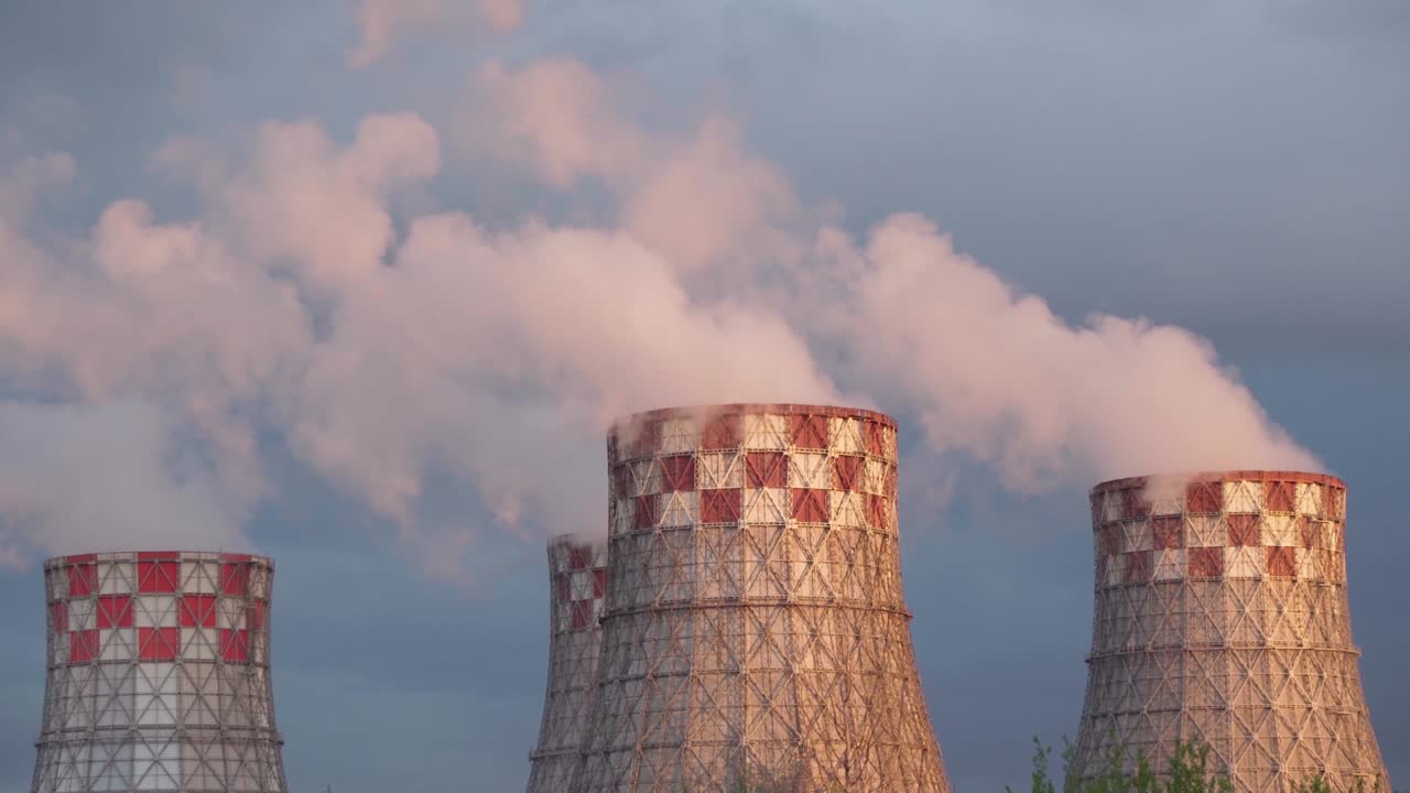 Tubi di fabbrica centrali termiche con denso fumo bianco dall'ambiente inquinante della centrale nucleare di energia termica
