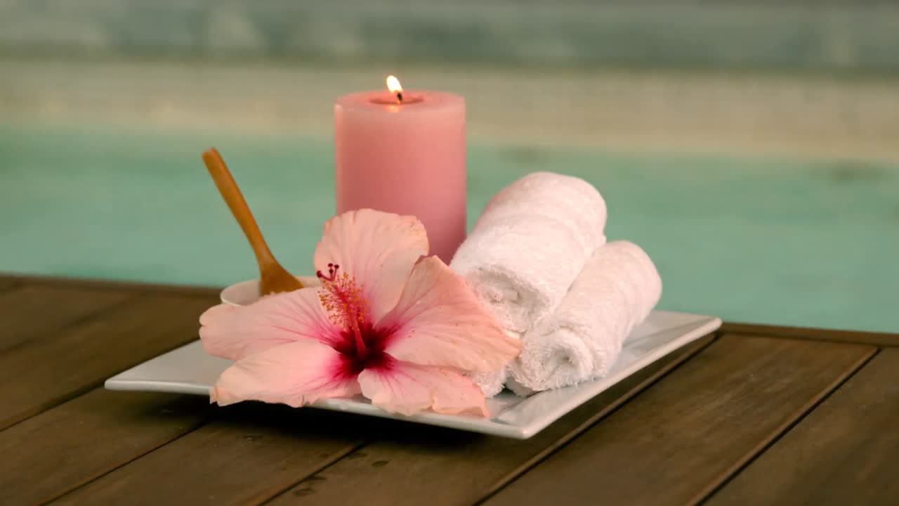 tratamientos de belleza y velas al lado de la piscina con lirios