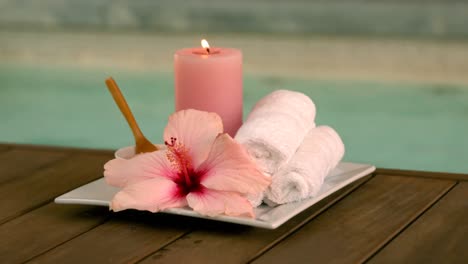 tratamientos de belleza y velas al lado de la piscina con lirios