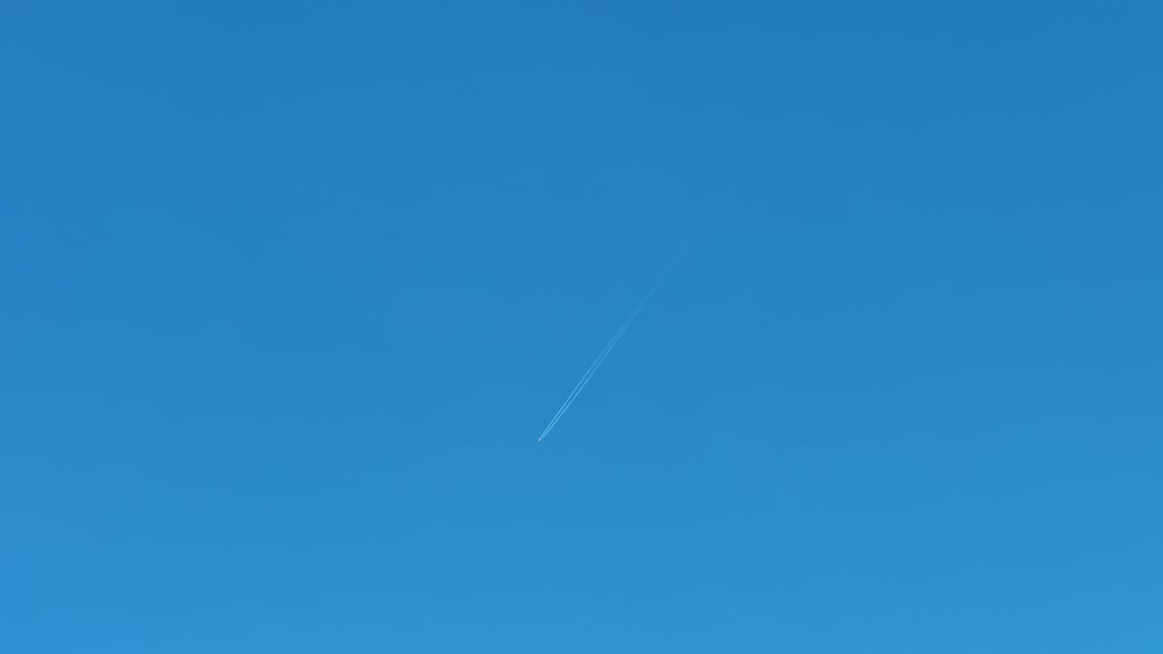 Cielo azzurro limpido con piccolo aereo che lo attraversa