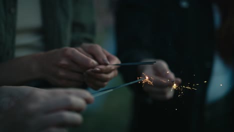 Close-up-of-hands-of-unrecognizable-people-enlightening-sparklers-on-music-festival.