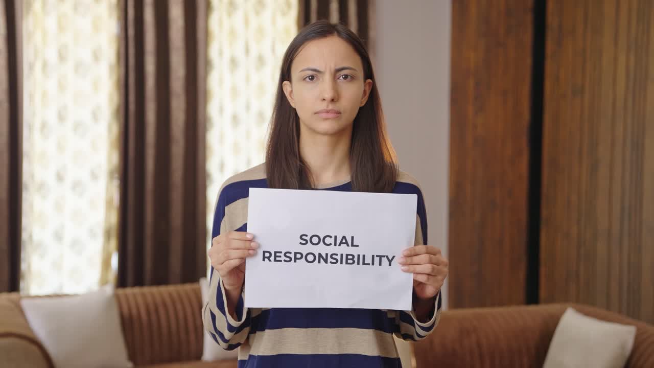 Indian woman holding SOCIAL RESPONSIBILITY banner
