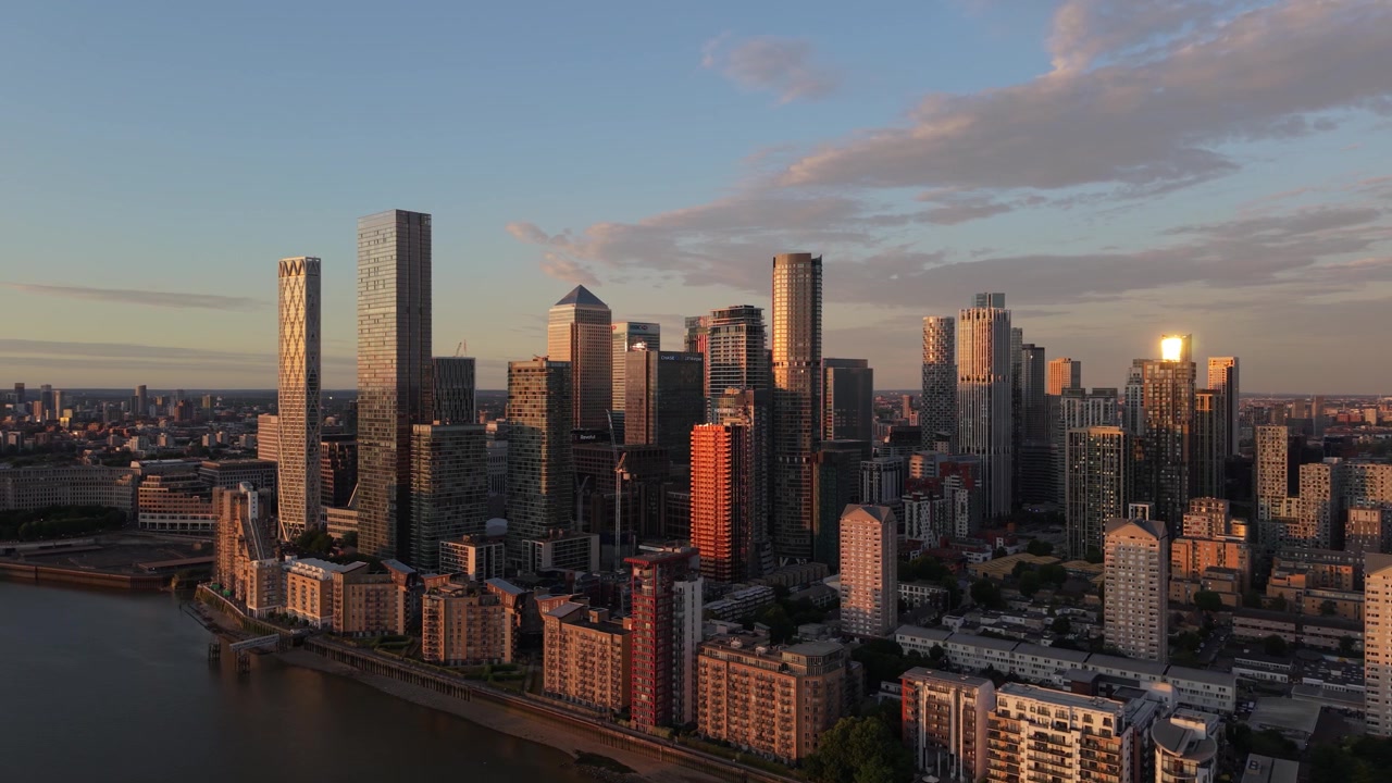 Vista aérea do horizonte de Canary Wharf em Londres durante a hora dourada. O sol reflete nos edifícios altos e modernos ao longo do Rio Tâmisa. Bela cena urbana ao pôr do sol