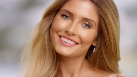 portrait of a smiling young blonde woman with blue eyes