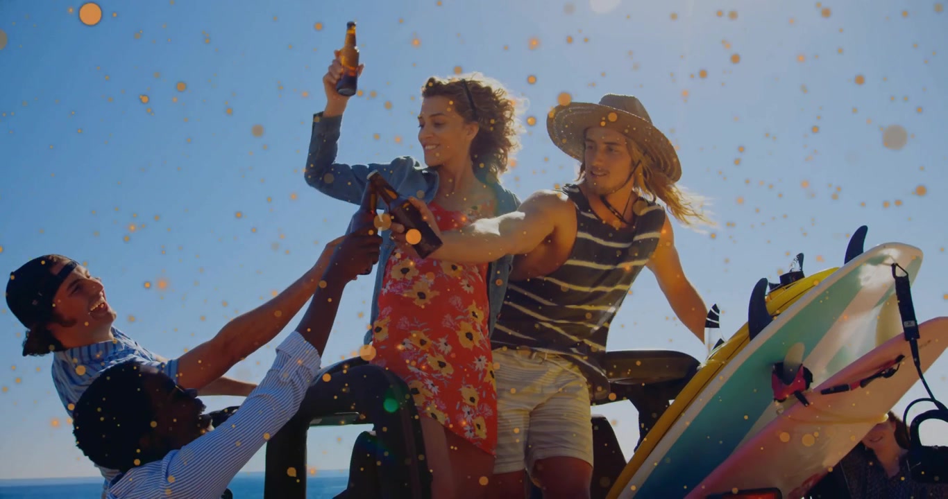 Amici che festeggiano una pubblicità di surf, alzando bottiglie di birra con coriandoli dorati che fluttuano intorno al portellone posteriore.