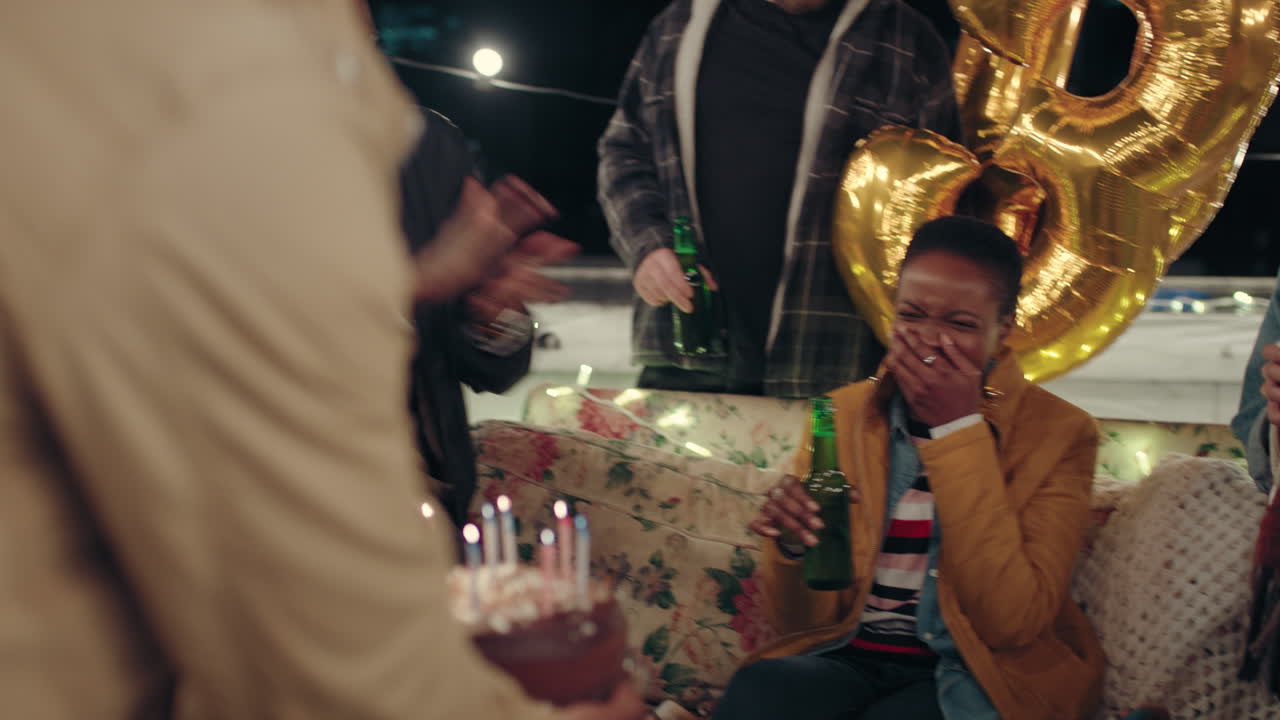 grupo de amigos diversos celebrando una fiesta de cumpleaños en la azotea por la noche hermosa joven disfrutando de un pastel sorpresa riendo divirtiéndose compartiendo la celebración