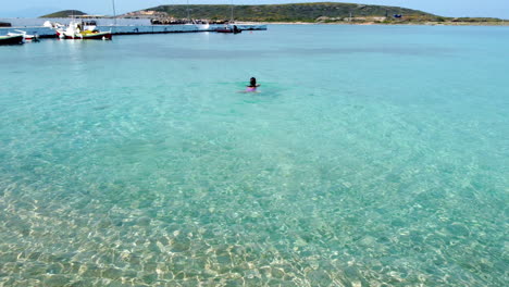 Frau-Im-Bikini-Auf-Der-Meerwasseroberfläche,-Schwimmen-Im-Transparenten-Mittelmeer,-Sommerferienkonzept