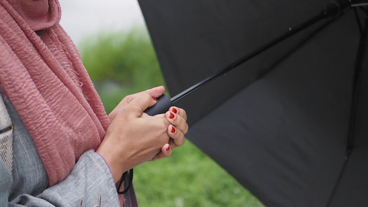 검은 우산을 들고 있는 여자
