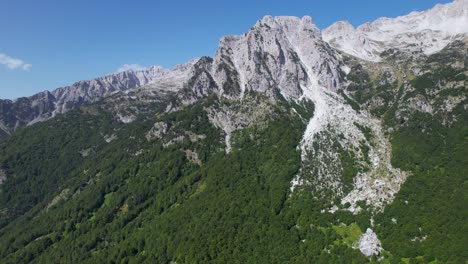 la majestuosidad épica de los alpes: una montaña imponente con escarpados picos rocosos y laderas verdes y boscosas, el majestuoso espectáculo de la naturaleza