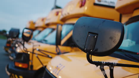 una serie de autobuses escolares para el transporte de escolares. primer plano de piezas de automóviles y fila trasera de otros vehículos