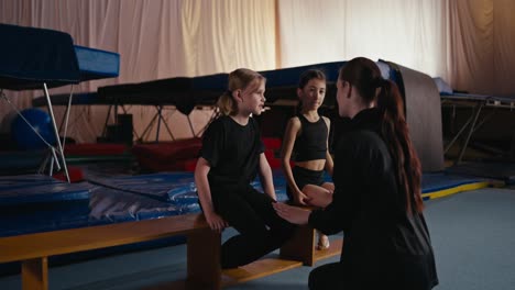 young gymnasts training with their coach in a gym