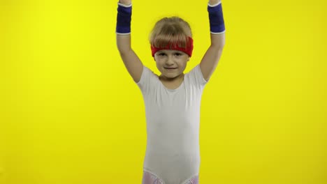 Happy-cute-girl-in-white-sportswear-showing-thumbs-up-gesture-isolated-on-yellow-background.-Fitness