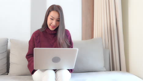 Close-up-young-woman-working-hard-on-her-laptop-enjoying-the-fruits-of-her-labor