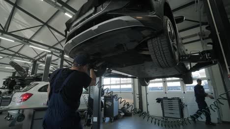 mechanic repairing car engine in auto workshop