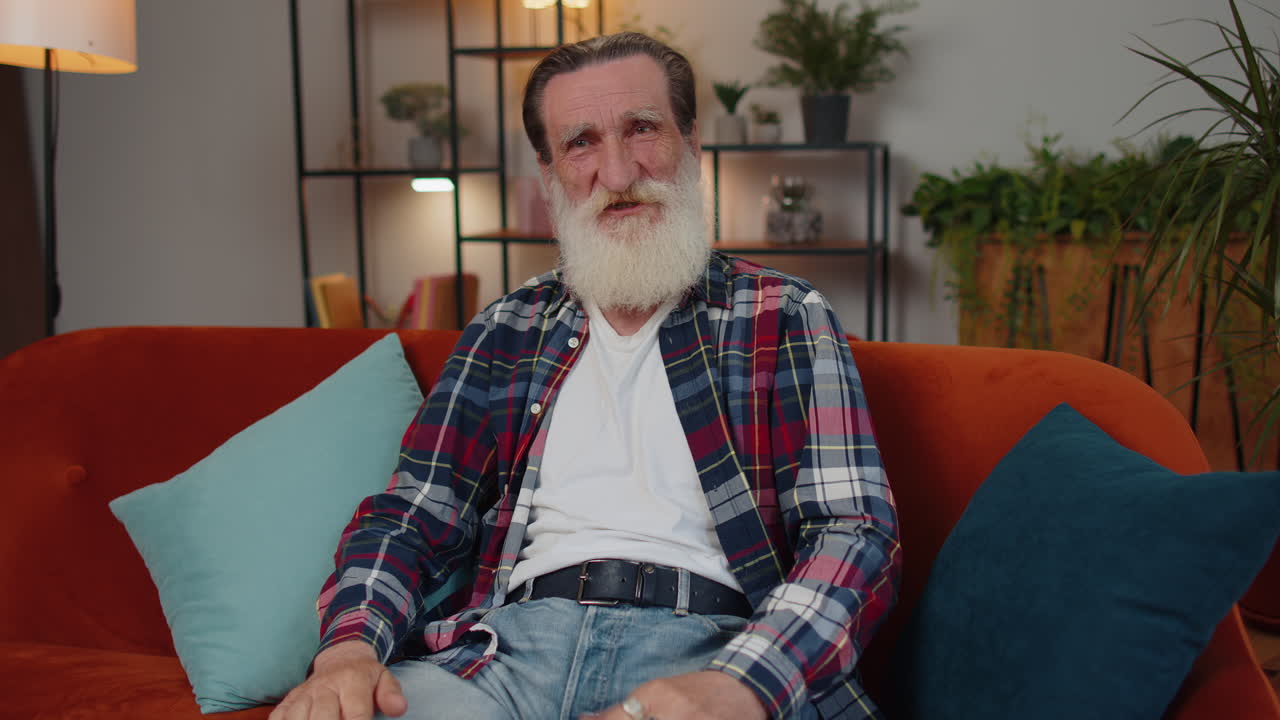 un anciano abuelo feliz mirando con aprobación a la cámara mostrando los pulgares hacia arriba, como un signo positivo