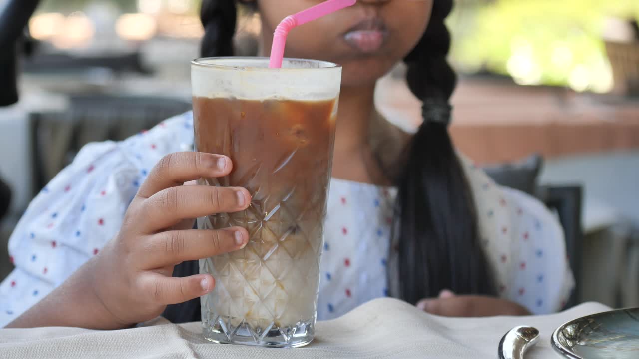 A child drinking iced coffee