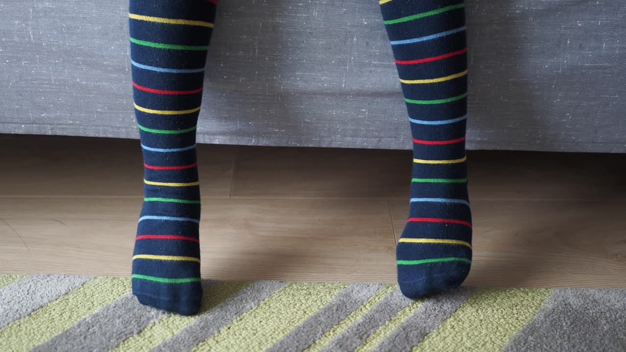 las piernas del niño con calcetines a rayas