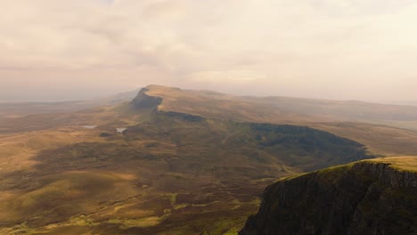 Aerial drone footage of the dramatic mountain landscapes on the Isle of Skye, Scotland. Sweeping panoramic views of majestic peaks, green valleys, and wild nature