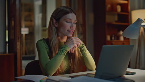 online tutor talking webcam chat laptop computer in evening apartment close up.