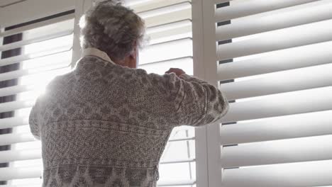 Rückansicht-Einer-Afroamerikanischen-Seniorin,-Die-Zu-Hause-Aus-Dem-Fenster-Schaut