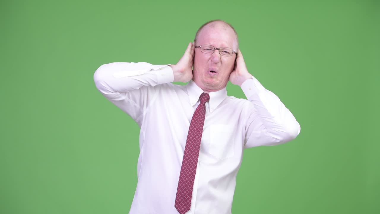 스트레스를 받은 성숙한 머리 사업가 귀를 고