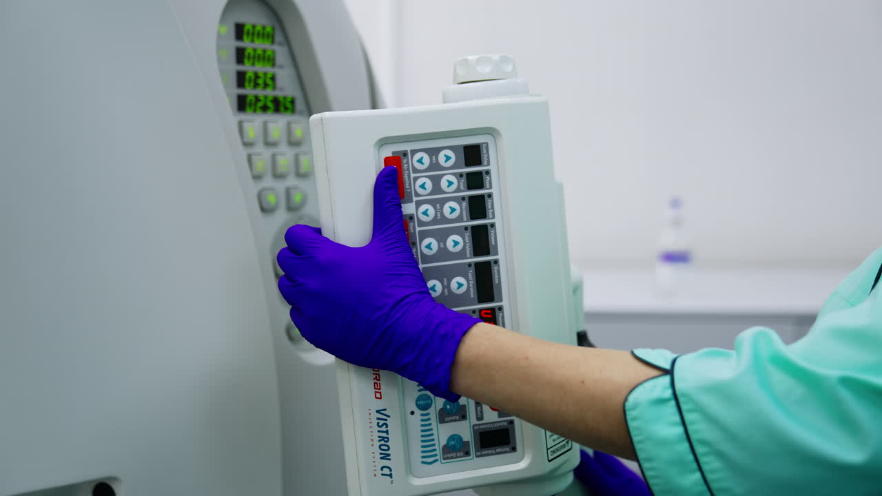 Pressing the buttons on the equipment control panel. Lab technician turns on the magnetic resonance scanner.