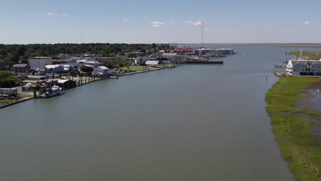 Drone-dolly-along-river-to-Chincoteague-Island-harbor-Virginia,-slow-motion