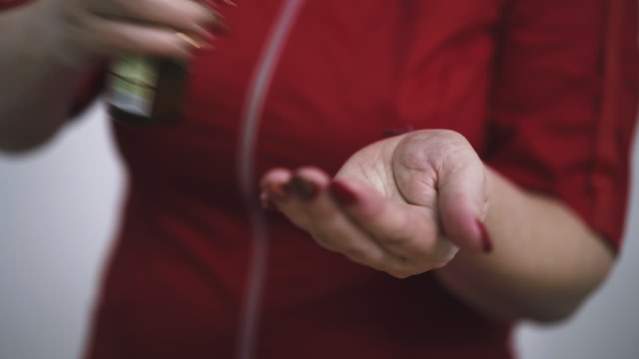 woman massage therapist applies oil onto palms in clinic