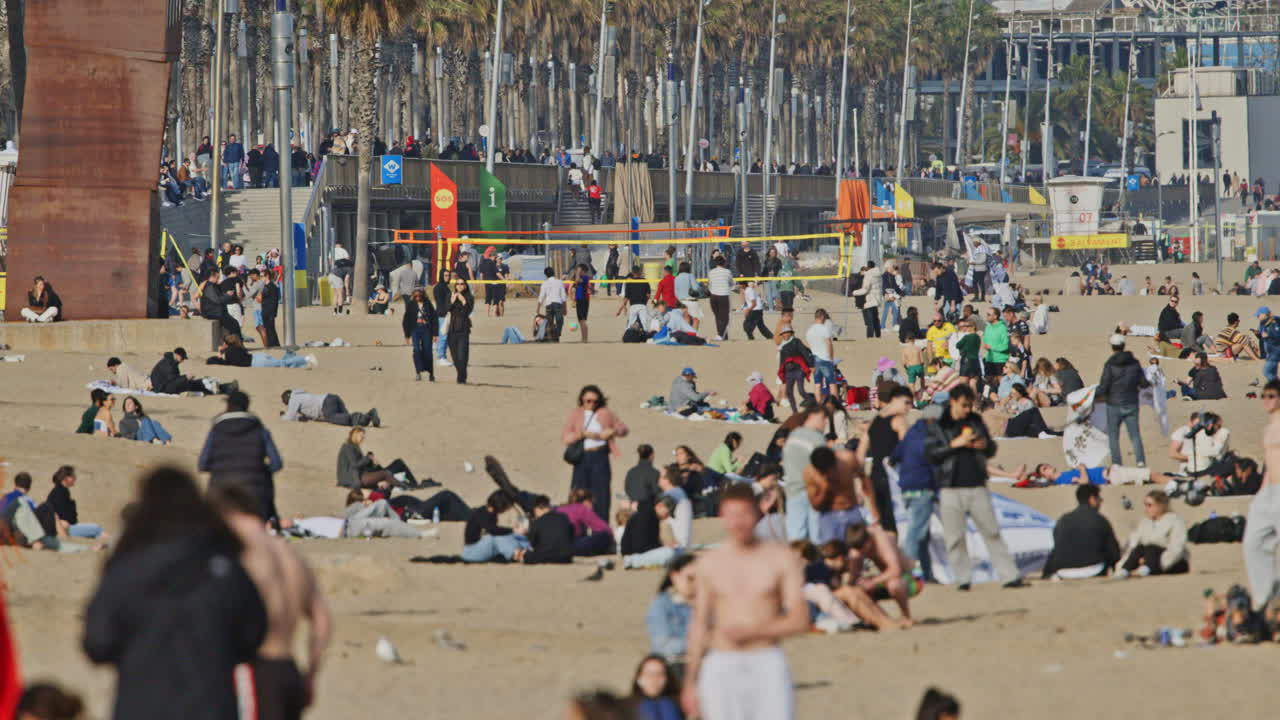 Persone che si godono una soleggiata giornata invernale sulla spiaggia di Barcellona