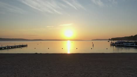 Goldene-Stunde-Am-Strand-Aus-Der-Luftaufnahme-Vorbei-An-Docks-Und-Rettungstürmen