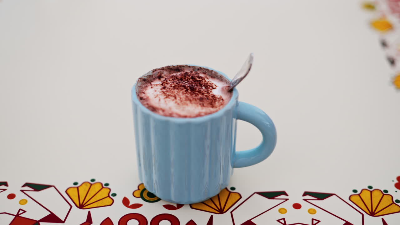 Close up of hot chocolate in a blue cup on a white table